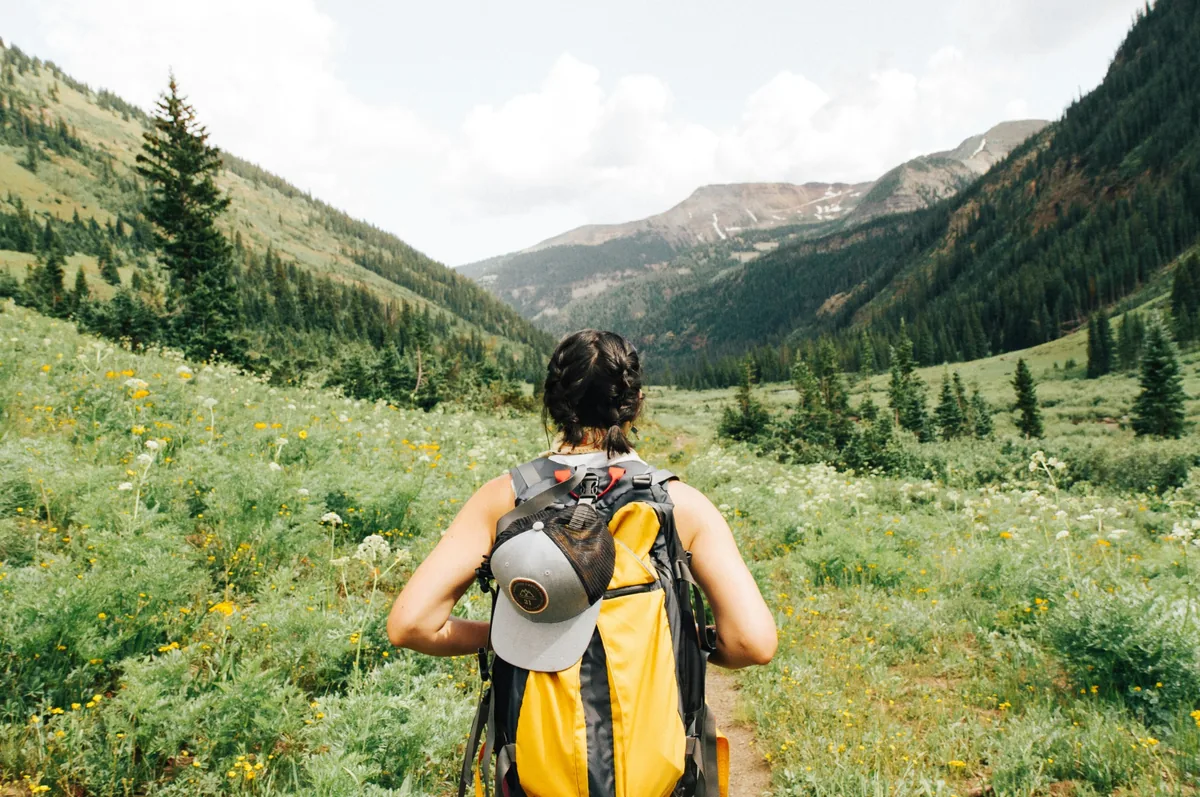 Wanderin mit Rucksack unterwegs in einer Berglandschaft
